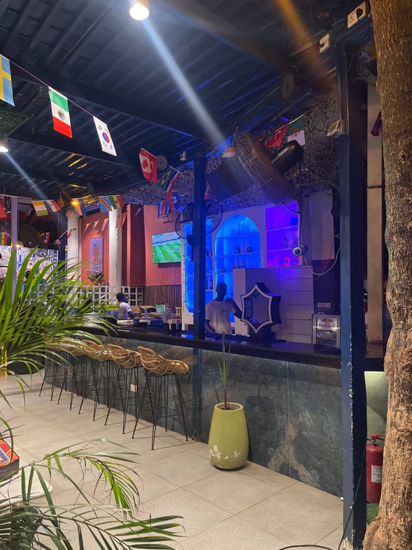 Accra bar venue with flags, neon art, and international flair