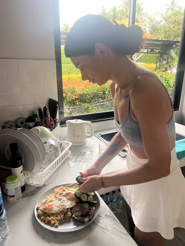Woman cooks breakfast with fried eggs in Thai kitchen