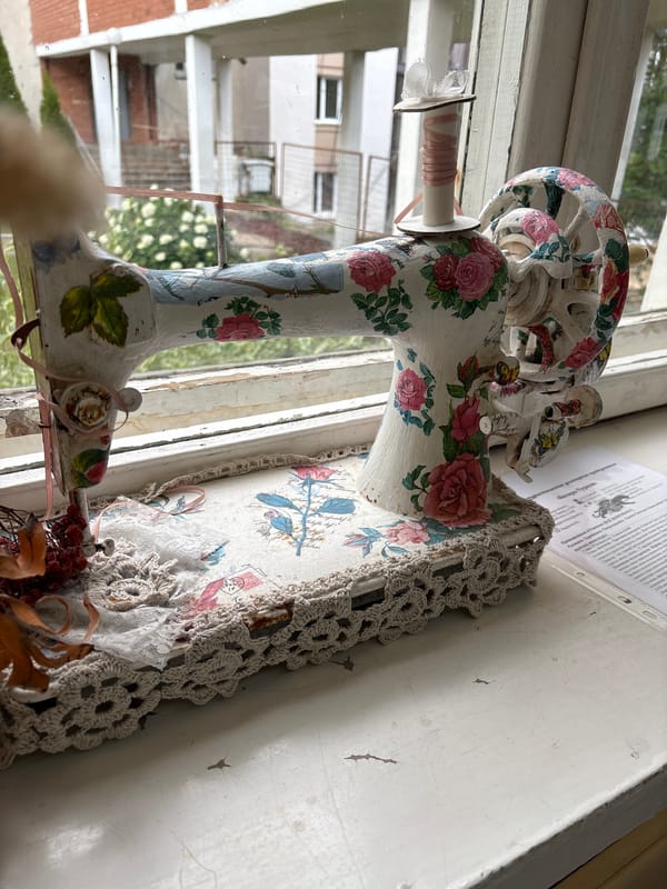 Floral-painted decorative sewing machine on a Vitsebsk windowsill