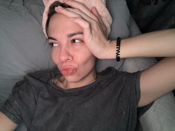 Woman rests on bed with towel in Ust-Ilimsk