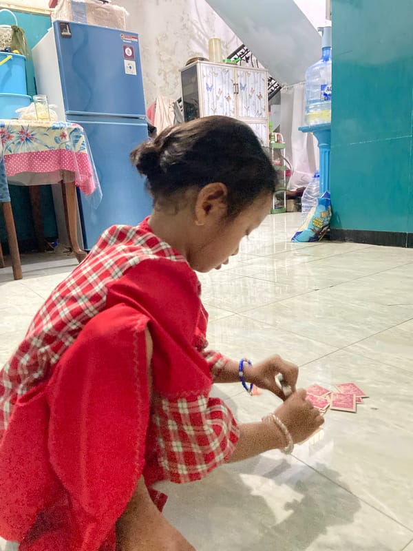 Child plays with cards at home in Gelam