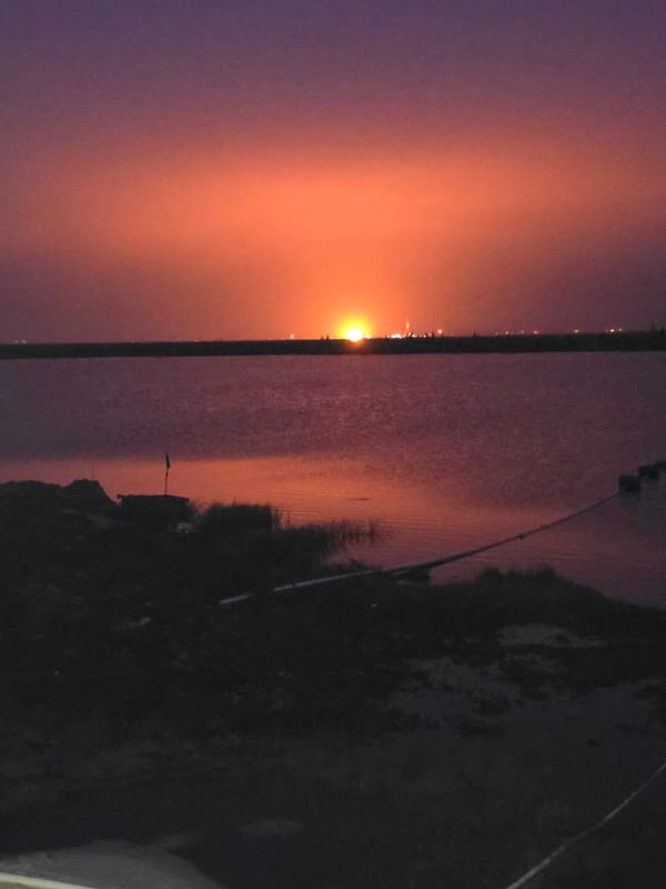 Sunset over water, sky shifting purple to orange