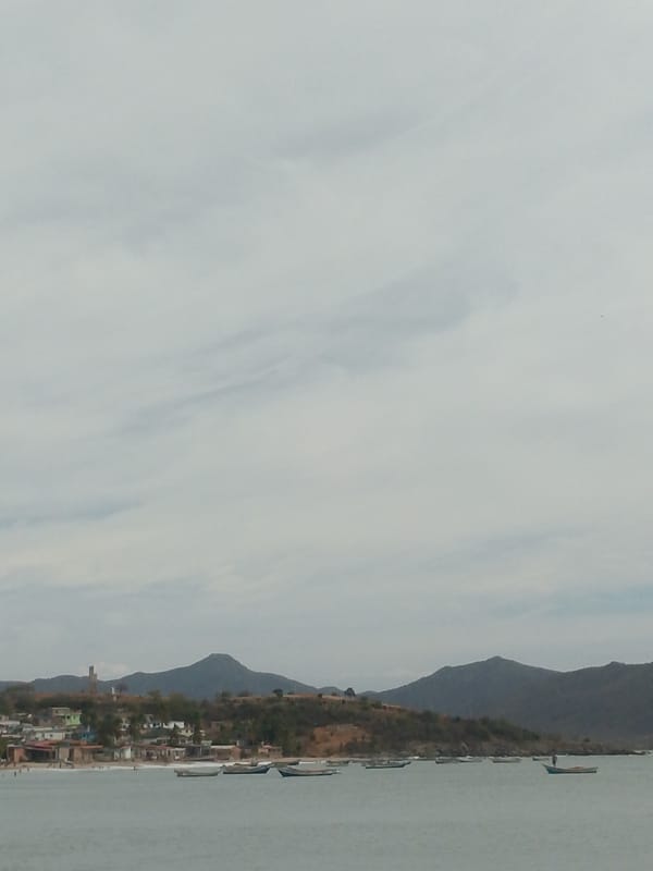 Busy afternoon at Juan Griego beach under cloudy skies