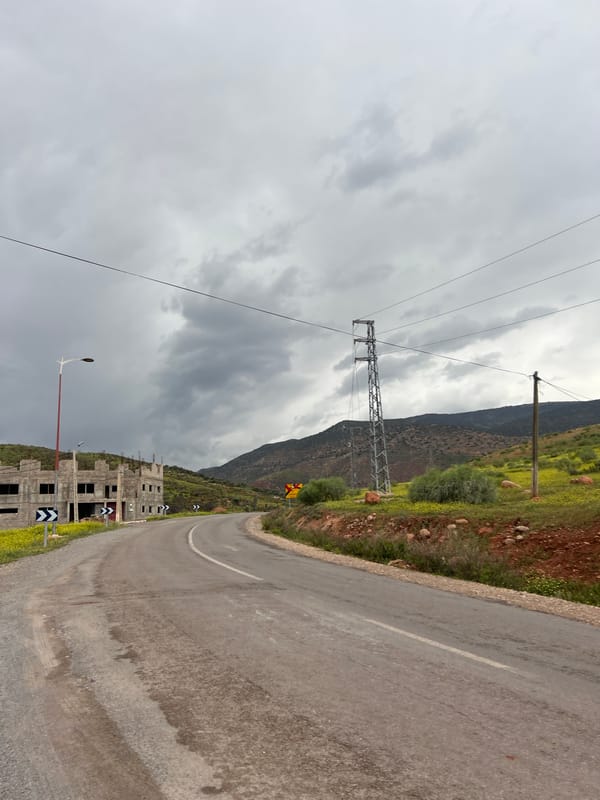 Drive through Ouaouizert reveals roadside construction, overcast skies