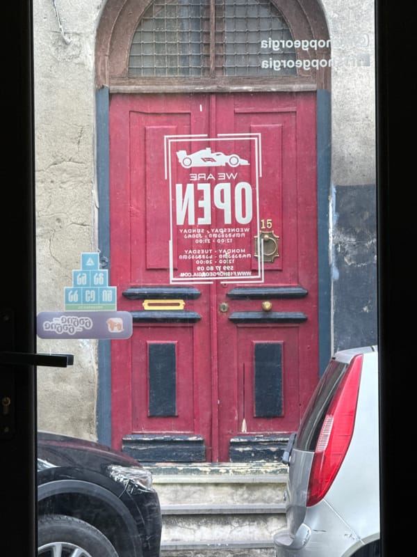 Open business and parked car observed on city street