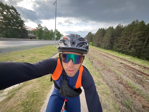 Early morning cyclists ride through Chaikovsky, Russia near railway tracks