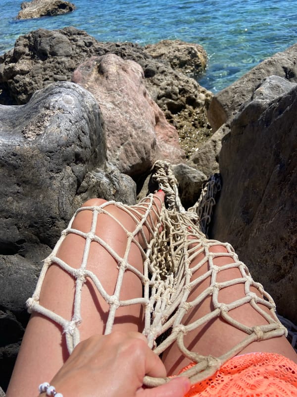 Woman relaxes on rocky Montenegro coast during sunny afternoon