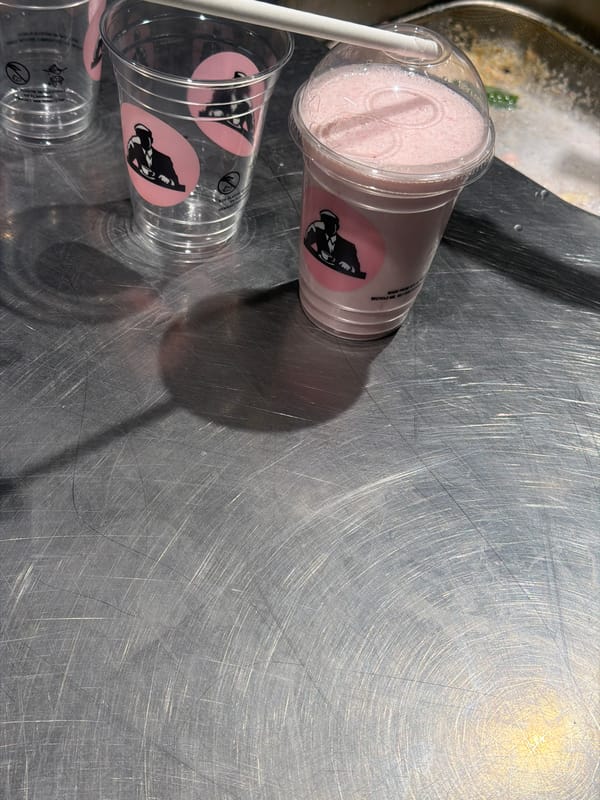 Pink drink photographed with empty cups in Paris