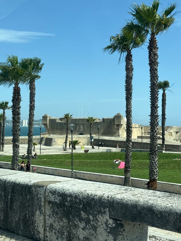 Coastal drive through Oeiras with beach and fortress views