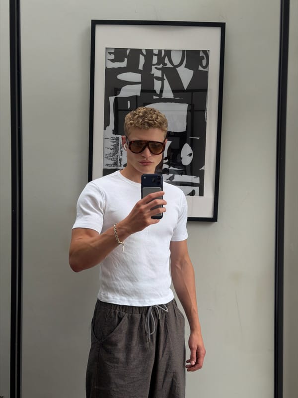 Mirror selfie in a London home, checkered trousers and white tee