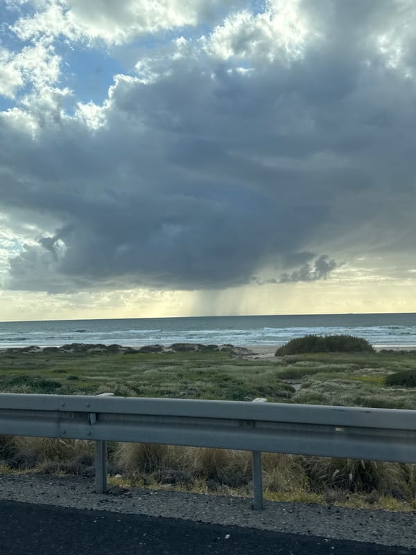Storm clouds contrast with sunlight over Tirat HaCarmel coast
