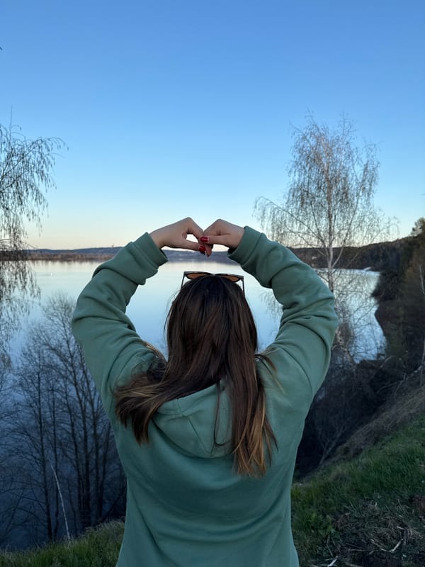 Person makes heart gesture at waterside in Chernushka, Russia