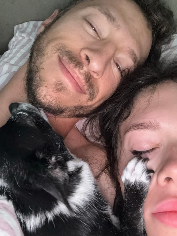 Two people, dog rest together indoors in early morning