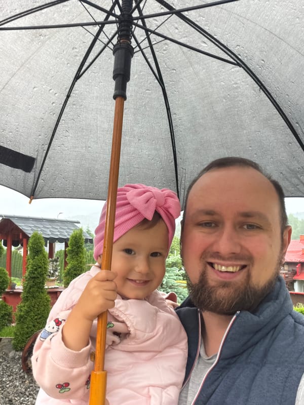 Father and child share umbrella selfie moment in Wisła
