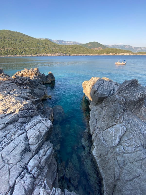 Turquoise water flows through a rocky coastal channel