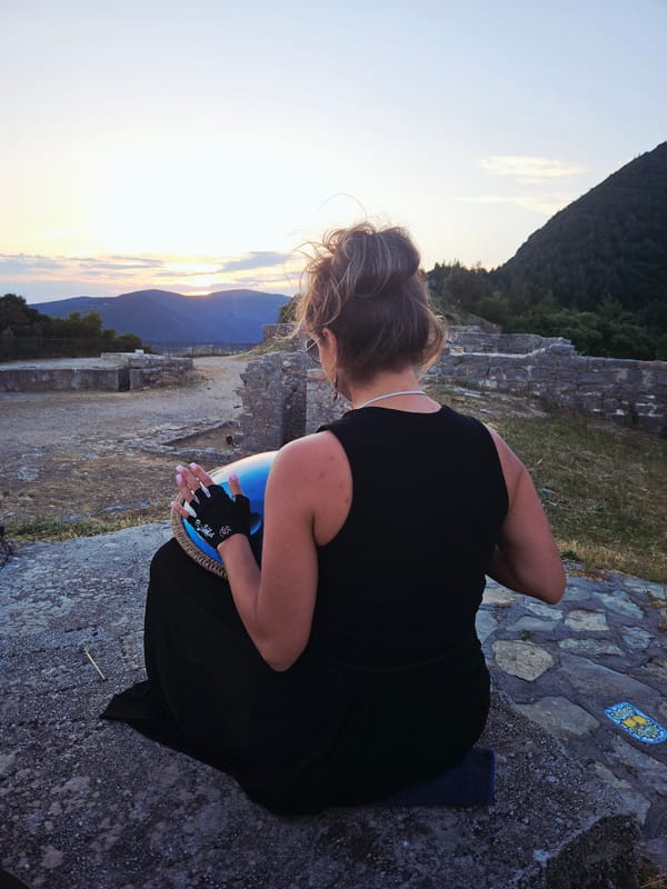 Woman plays handpan during sunset at ancient stone location