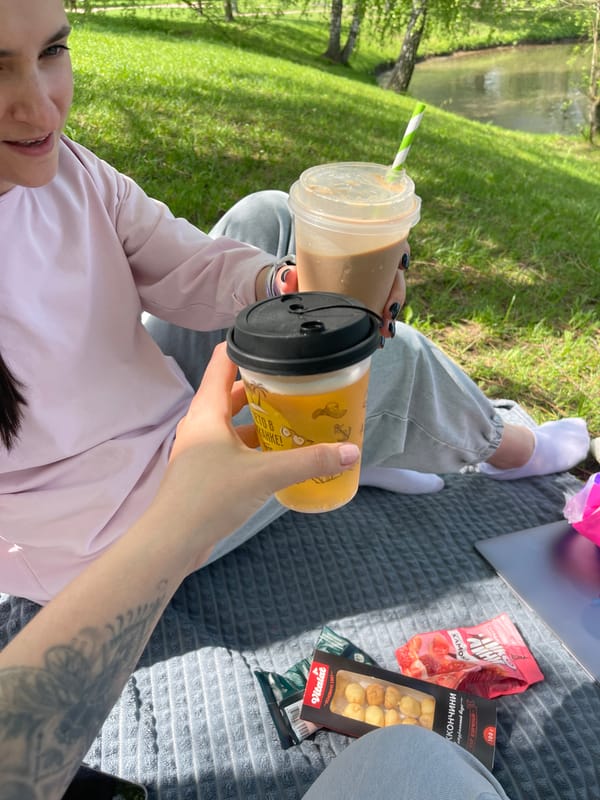 Moscow parkgoer enjoys morning picnic by water with beverages