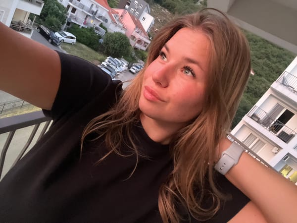 Woman films selfies at dusk from Budva balcony
