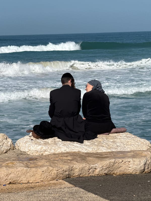 Surfers and beachgoers active along Tel Aviv Mediterranean coast