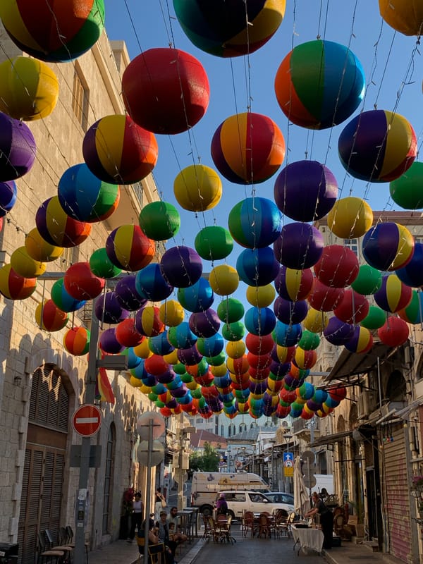 Lantern-lit Tel Aviv street with quirky outdoor lounge setup