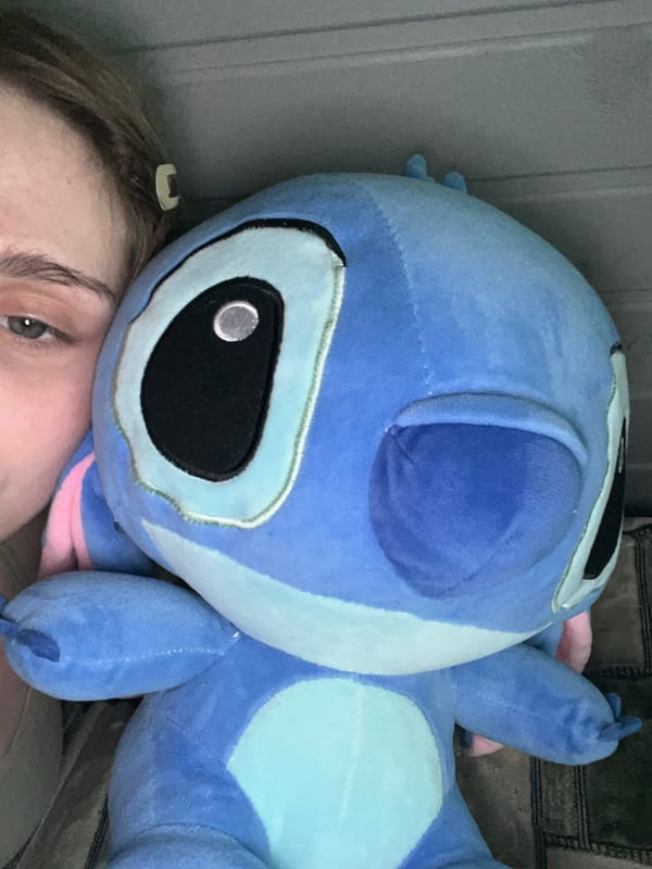 Laid-back at-home selfie session with Stitch plush and beauty products