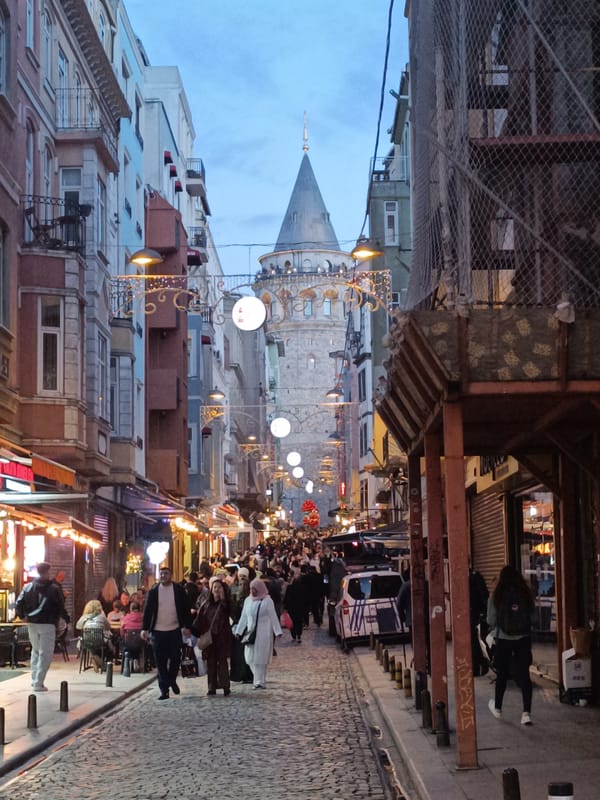 Crowded cobblestone street scene captured near Galata Tower, Beyoğlu