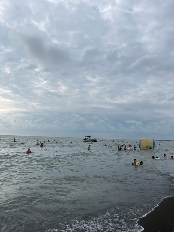 Crowded summer day at Ureki's Black Sea black sand beach