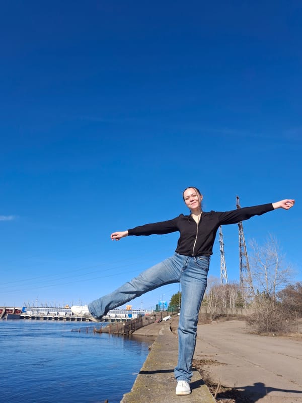 Woman photographs herself along Chaikovsky waterfront during sunny morning