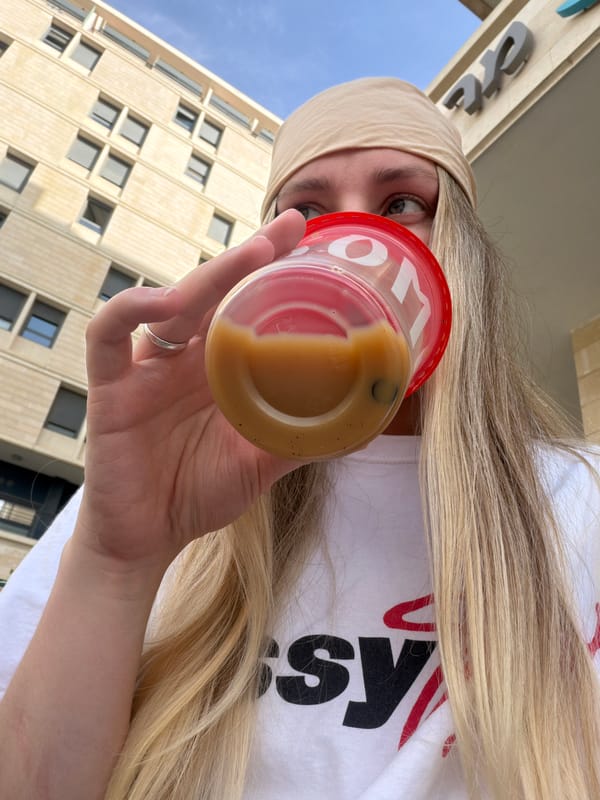 Woman enjoys layered drink outdoors in Tel-Aviv