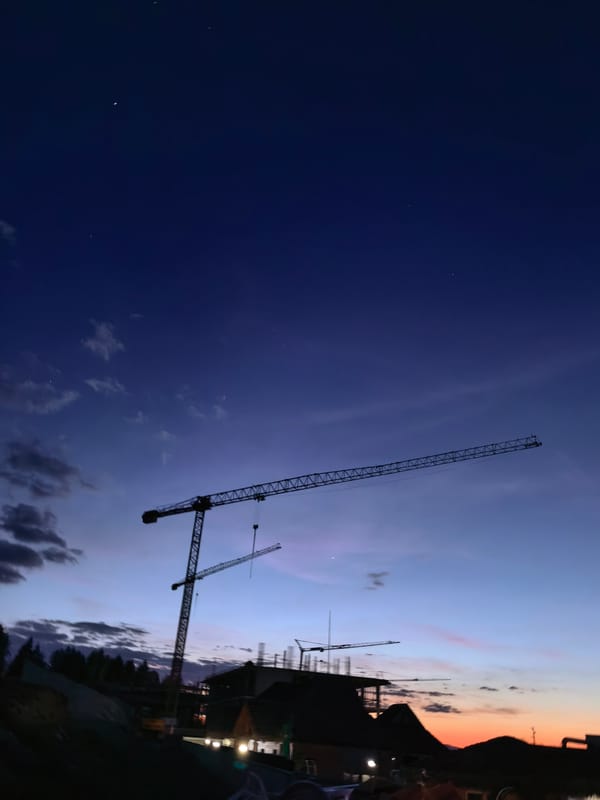 Construction cranes silhouetted at dusk in Sapareva Banya, Bulgaria