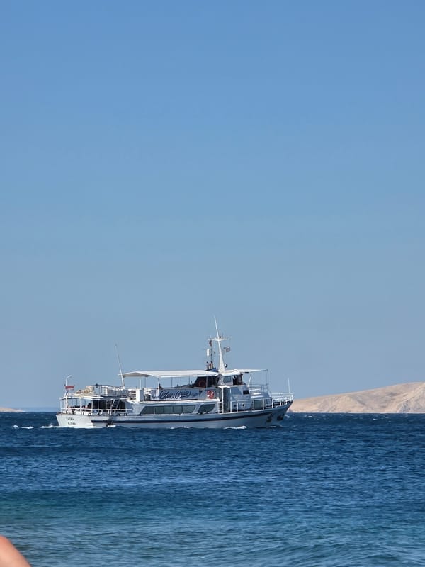 Blue Cruise ferry sailing along a rocky Croatian coastline