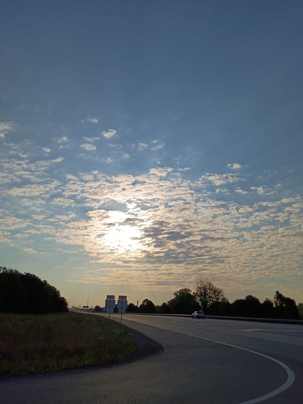 Open highway near Richmond, KY under a sun-streaked sky
