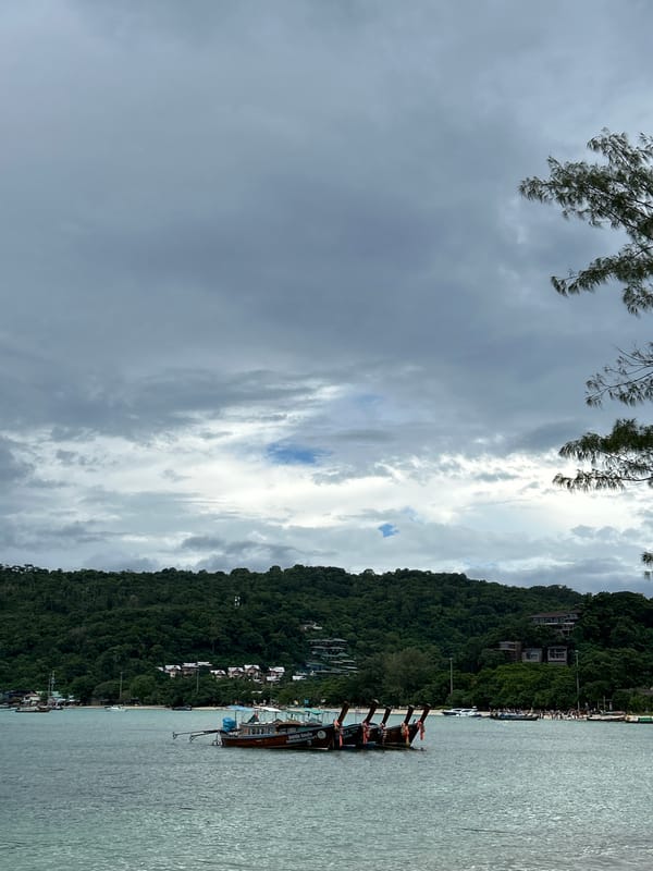 Ao Nang coastline: boats, karst cliffs, and beach at dawn