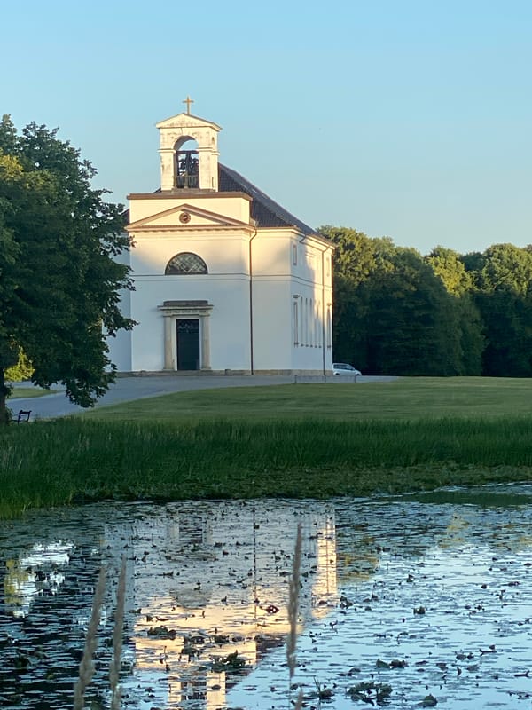 Hørsholm Church at golden hour, with a cyclist passing by