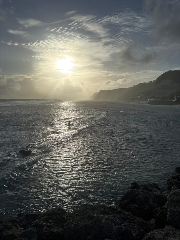 Tourist explores Melasti Beach coastline during overcast morning in Bali