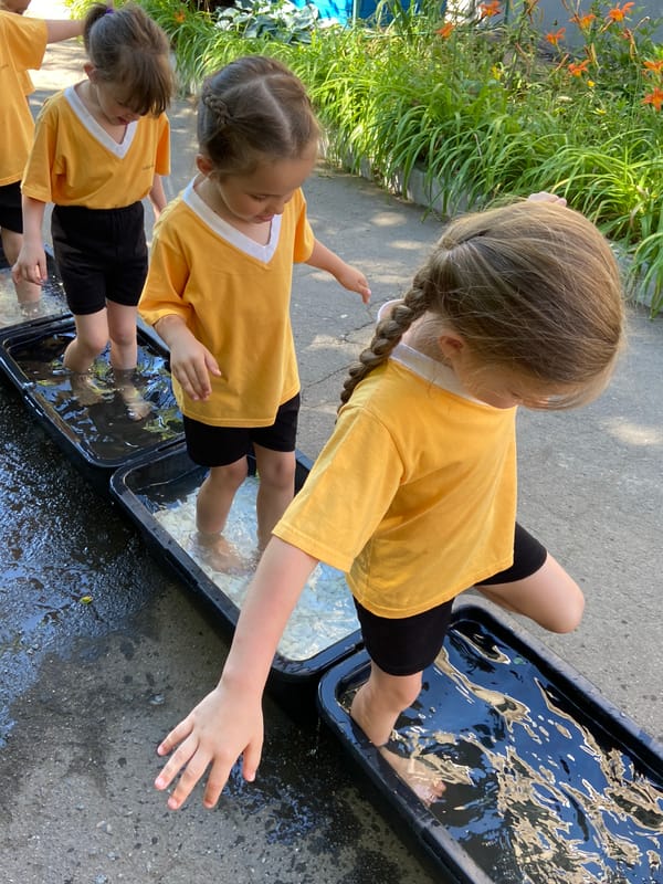 Kids splash in water tubs on a warm summer day outdoors