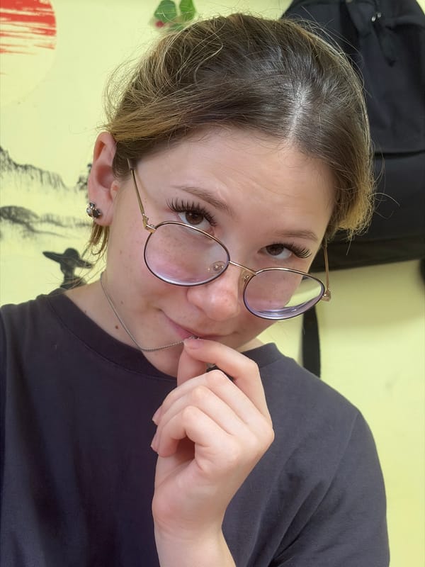 Casual portrait series, glasses and dark tee, relaxed setting.
