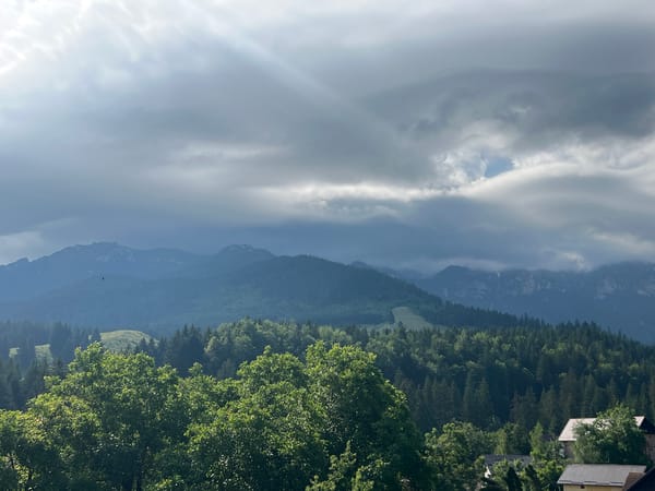 Inside and outside a rustic mountain cabin on an overcast morning