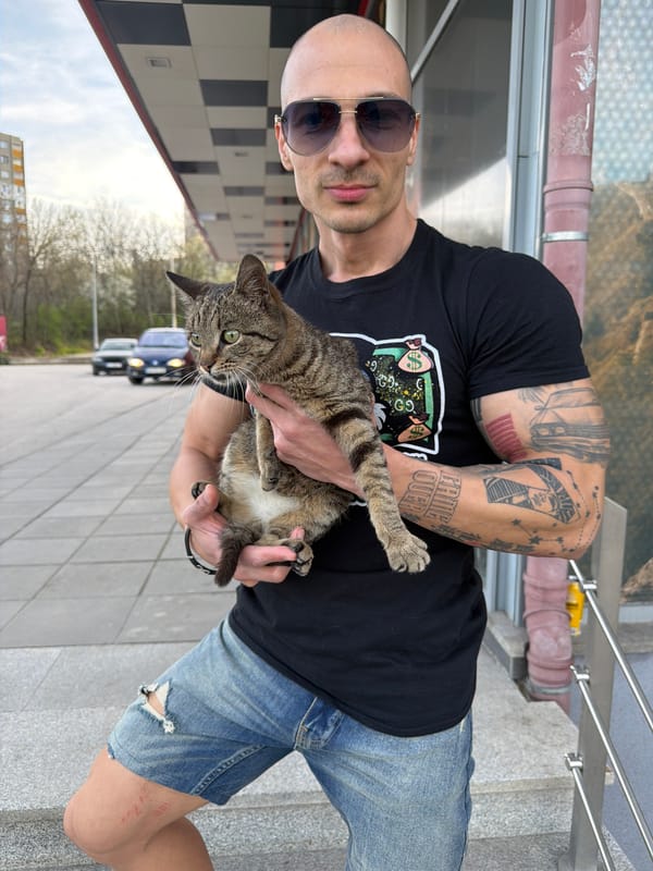 Man holds tabby cat on street in Pleven, Bulgaria