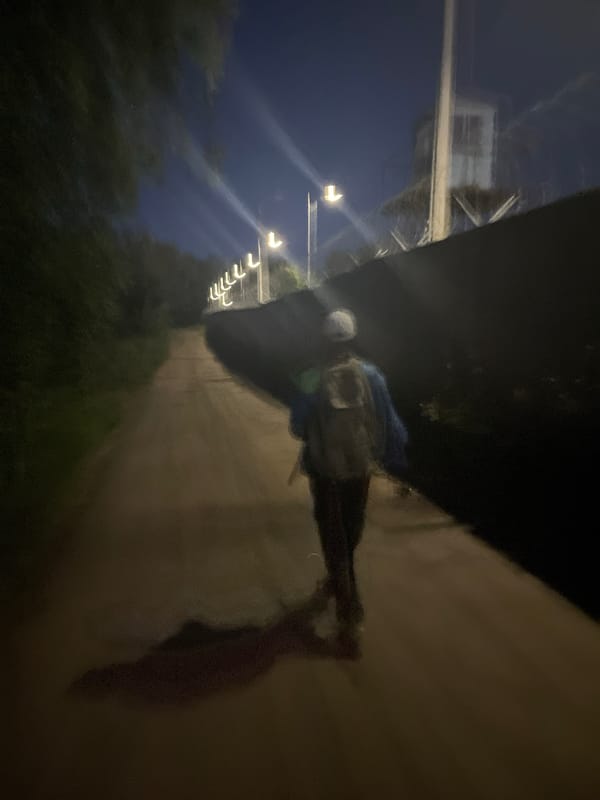 Night fisherman walks industrial paths near Chaikovsky power infrastructure