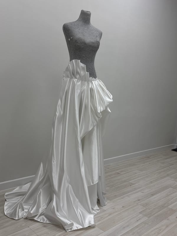 Wedding gown displayed on dressmaker's form in Perm