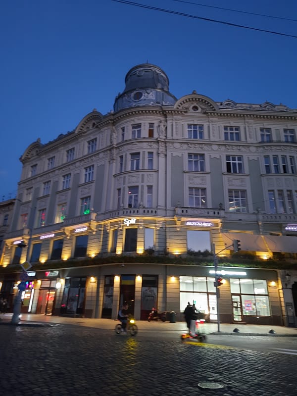 Ornate domed building at dusk on a Lviv street