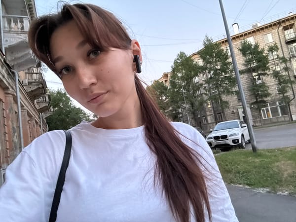 Selfie session outside a Novokuznetsk apartment block, summer evening