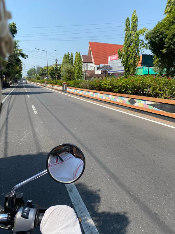POV motorcycle ride through a sunlit Madiun street