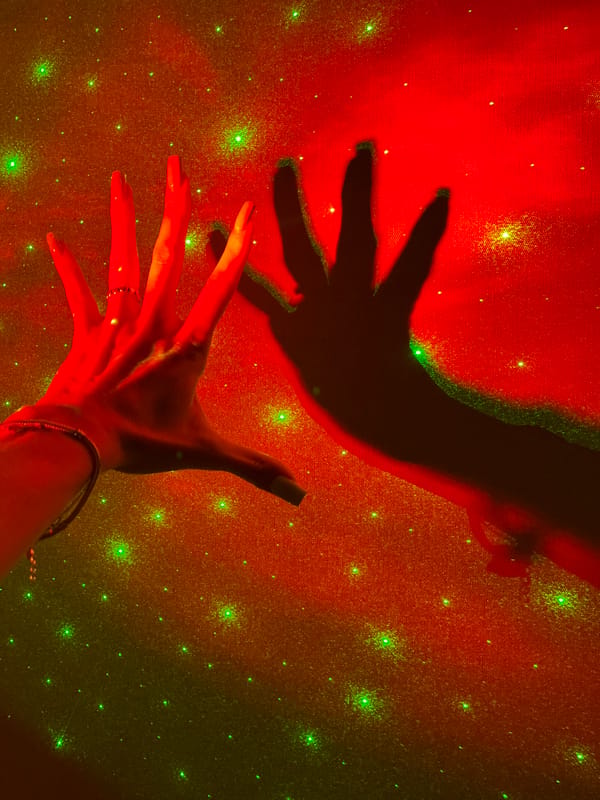 Hands play in galaxy projector light in a Nizhny Novgorod room
