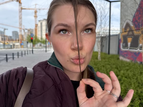 Woman plays with hair near flower sculpture in Belgrade