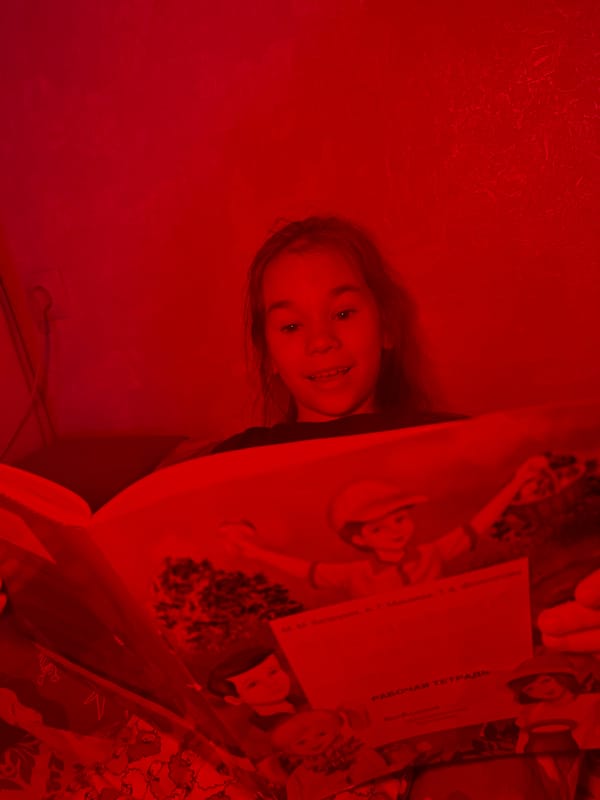 Young reader photographed during quiet indoor moments in Uva