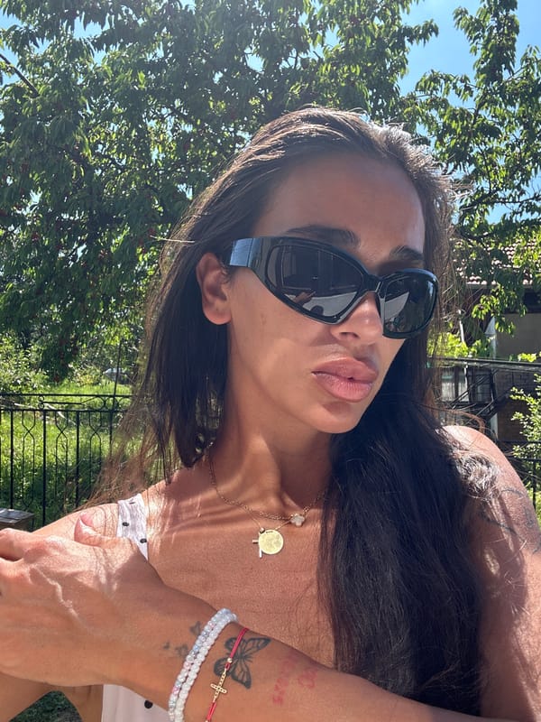 Polka-dot top and gold necklace, outdoors in Pernik