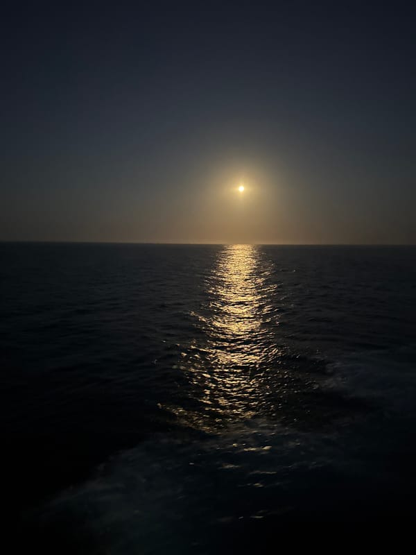 Sun and moon over the Atlantic, light paths on dark water