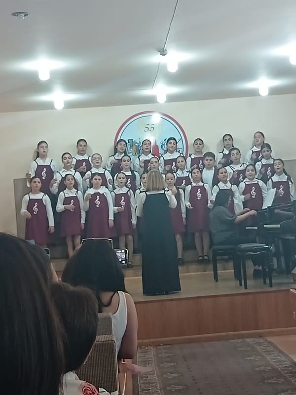 School music recital with choir, piano duets, and student performances